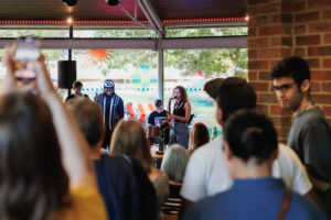 Looking to a band performing from the crowd, with other crowd members in front.