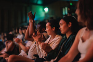 Audience members clapping and smiling