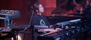 A woman with dark hair tied back sat playing a keyboard