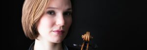 Young woman with short brown hair holding a violin