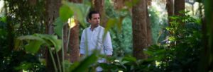 A man wearing a white shirt stood in a garden